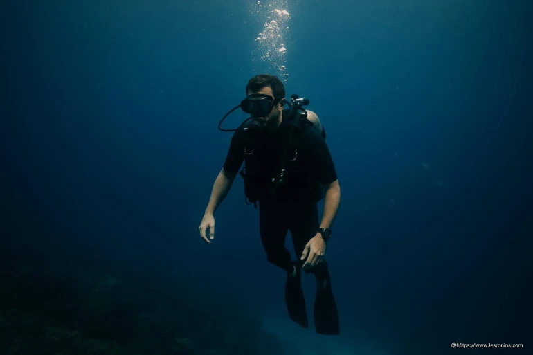 Plongeur en combinaison noire sous l'eau